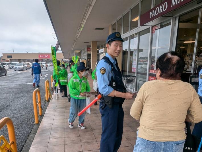 警察官が市民にチラシを配布するとともに防犯の呼びかけをおこなっている