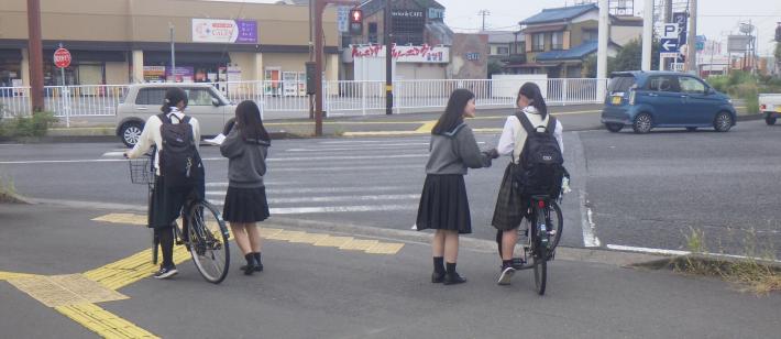 聖徳大学附属取手聖徳女子高等学校の生徒が自転車運転者に啓発品を配る様子