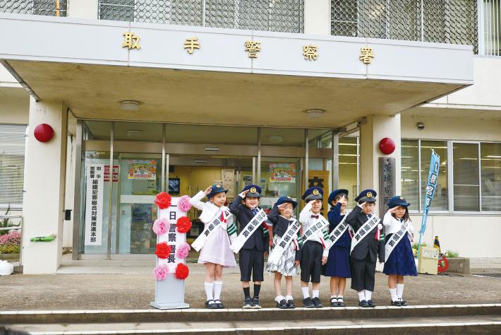 令和6年の一日警察署長7名が横一列に並び敬礼している