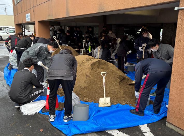 新規採用職員が土のうを作成している様子