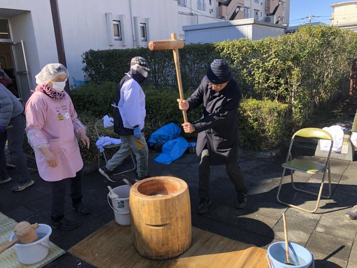 男性が餅つきをしている