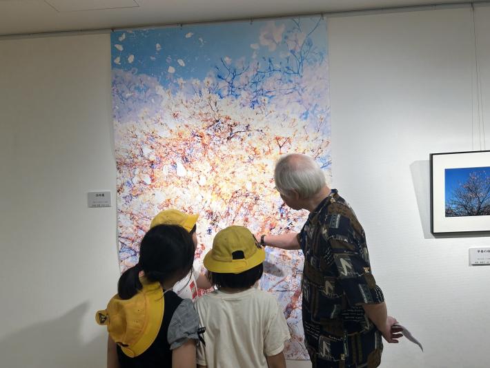 写真作品を鑑賞するこどもと大人