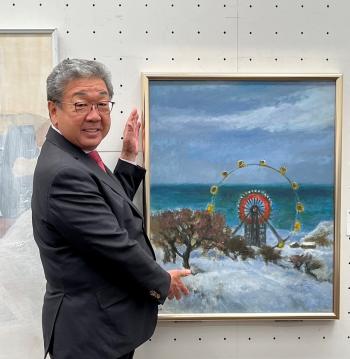 両手を添えて絵画を紹介する市長