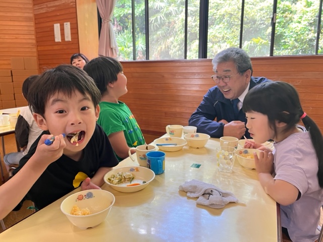 給食を一緒に食べる子どもたちと大人の男性