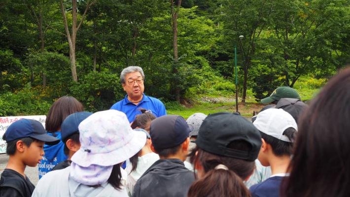 大勢の小学生に語りかける男性