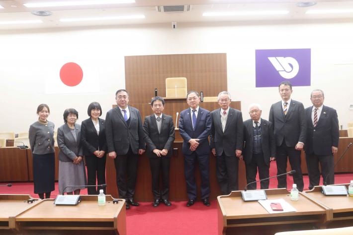 福岡県中間市議8名と取手市議2名が取手市議会議場の書記席前に横一列に並んでいる様子