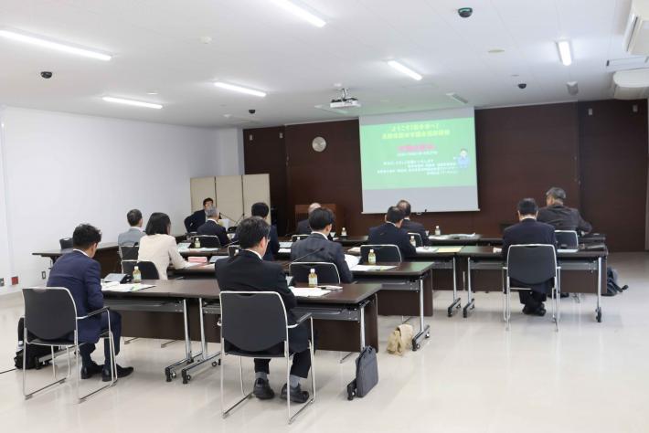 長野県飯田市議会の議員らが1日目に正面のスクリーンに投影された資料を見ながら説明を受けている様子