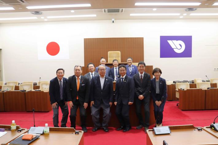 愛知県尾張旭市議会の議員らが2列に横に並んで記念撮影をしている様子