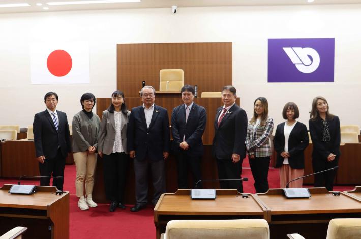 東京都新宿区議会の議員らが横一列に並んで記念撮影をしている様子