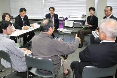 車座になって総務文教常任委員と市民が座っている。グループで意見交換をしている。男性が身振り手振りしながら意見を述べている写真