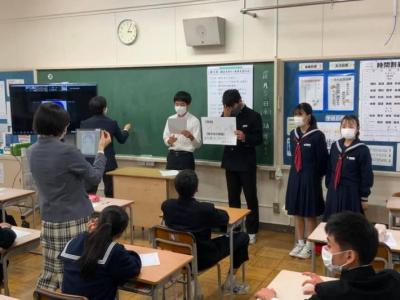 発表する生徒。代表が演台の前で発表先生がその様子を議員へ中継している