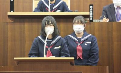 ルン党の中学生市議(女性生徒議員2人)が登壇し、説明している写真