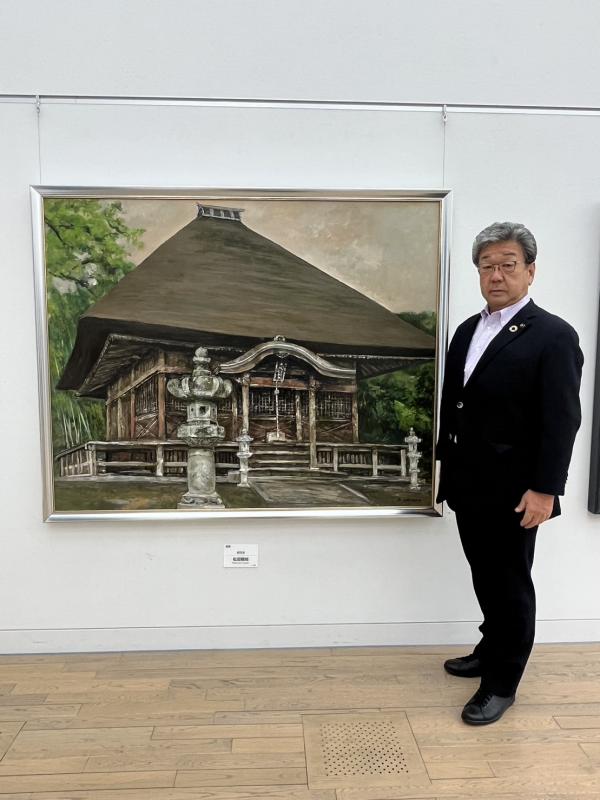 絵画の横に立つ市長