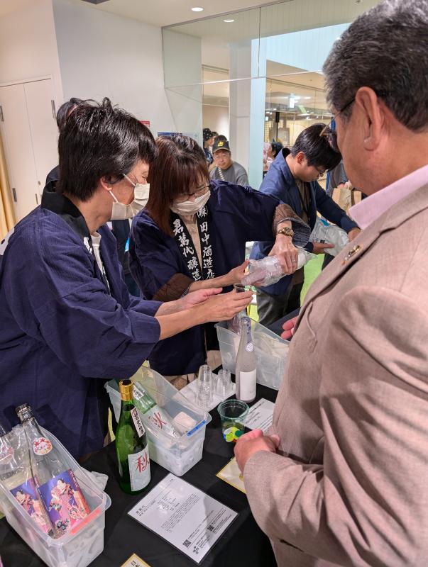 飲み物を注ぐ女性2人と男性