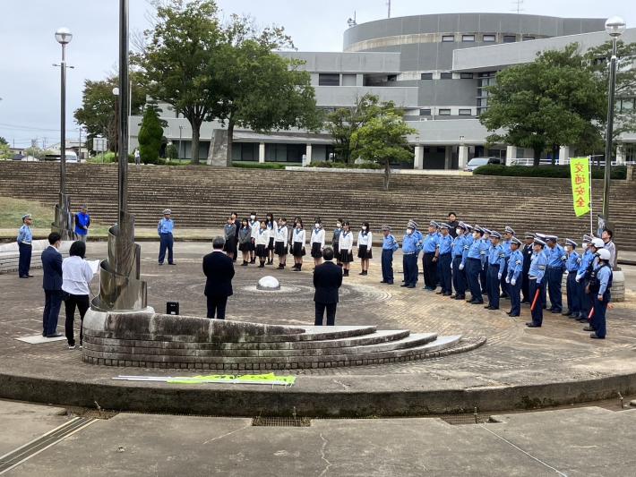 制服を着て、広場に集まる学生と交通指導隊