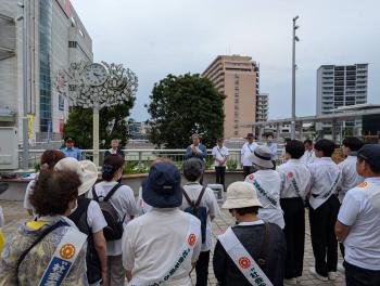 襷をかけた人たちの前であいさつをする市長