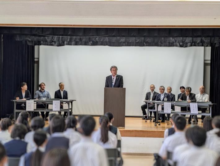 学校のステージ上で挨拶をする市長