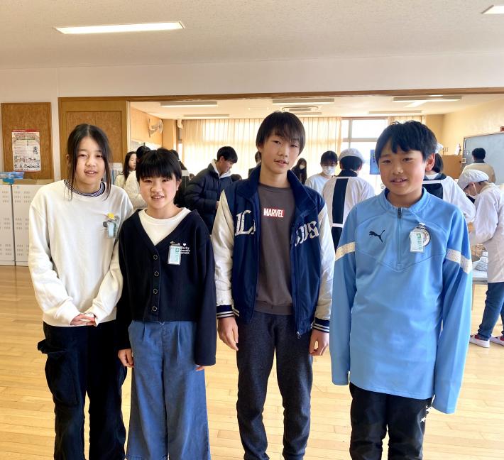 立って視線を向ける女子児童2名と男子児童2名