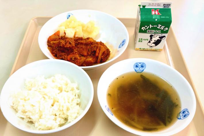 トマトカレー、粉ふきいも、スープ、牛乳がお盆にのっている