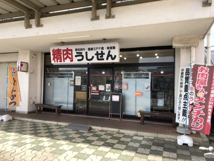 精肉うしせんと書かれた看板が掲げられた店。店の入口はガラス張りになっている。