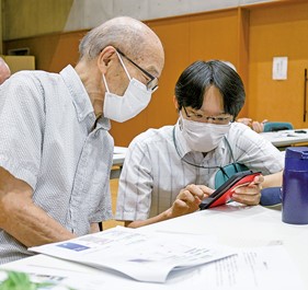 スマホ教室で市民に使いかたを教える男性職員