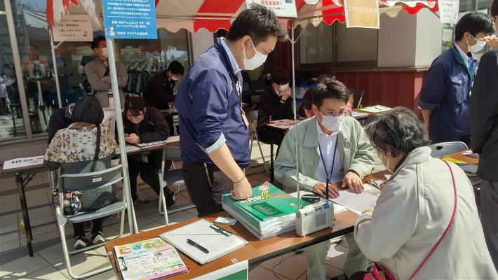 相談風景。机を挟み、高齢の女性と若い男性2人が何か話をしている様子。