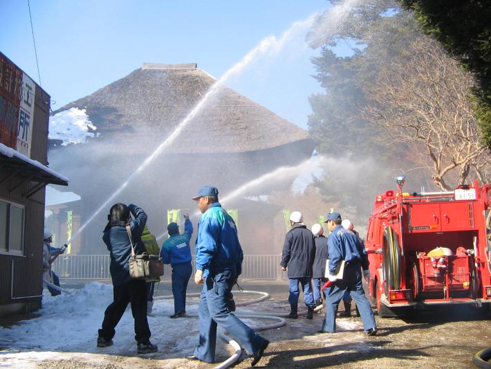 竜禅寺三仏堂に男性が水をかけている