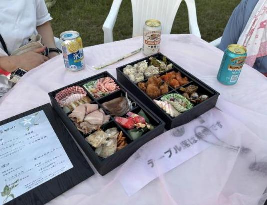 テーブル席。オードブルとお品書き、飲み物が写っています。