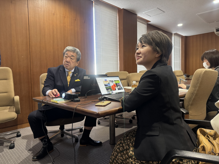 プロジェクターで審査写真を確認する中村市長とさくらまやさんの写真