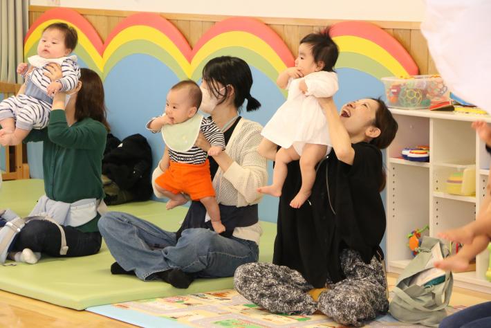 親3人が子どもを座って高い高いしている