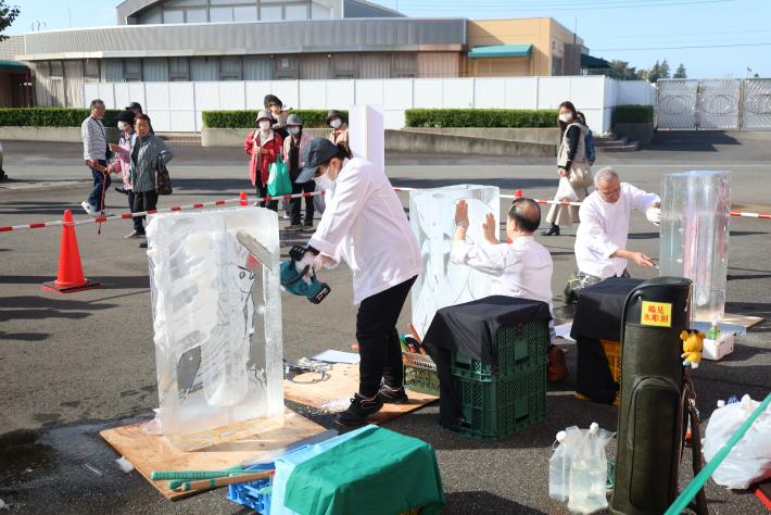 女性選手1名と男性選手2名が氷を削っている