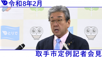 スーツを着た男性が記者会見をしている