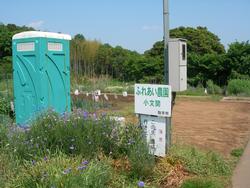 ふれあい農園小文間の画像。手前に看板と簡易トイレが見える。