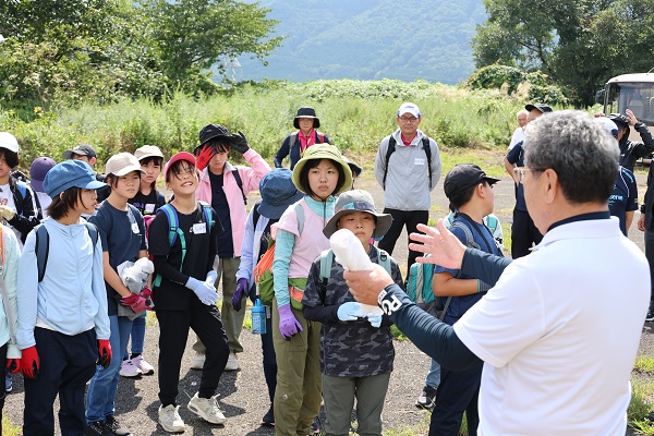 群馬県利根郡みなかみ町にて植林活動の説明を聞く小学生たち