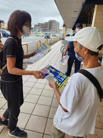 街頭キャンペーンで女性が啓発チラシを渡している様子