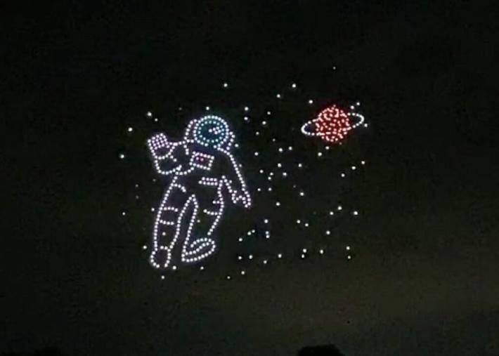 宇宙飛行士と土星を表現しているドローンショー。