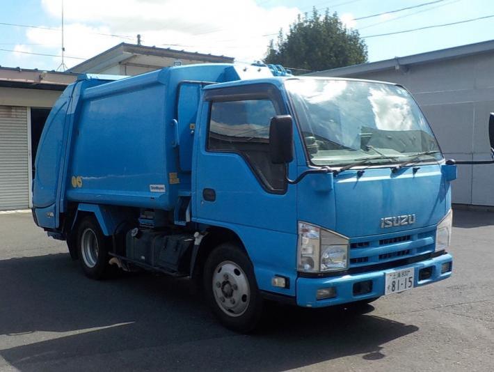 青い車体の塵芥車が駐車場に止まっている