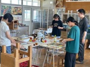 中学生3人が自分の作品を遠目から見て色の確認をしています。