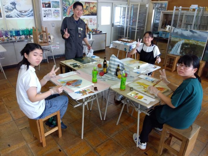 中学生3人が色をつけて塗って下絵を作っています。